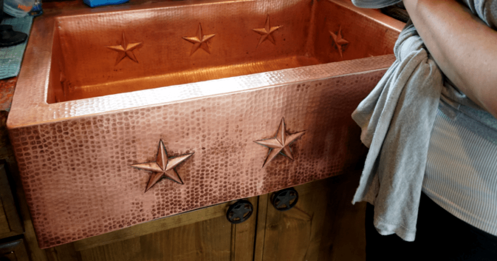 large farmhouse copper kitchen sink with stars - in the process of cleaning copper sink