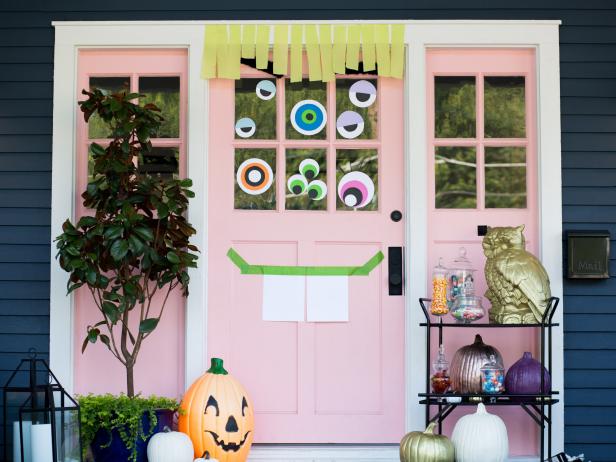 cheap and easy Halloween door decorations from HGTV where you make your front door covered with eyeballs and a simple mouth using just paper, tape, and streamers