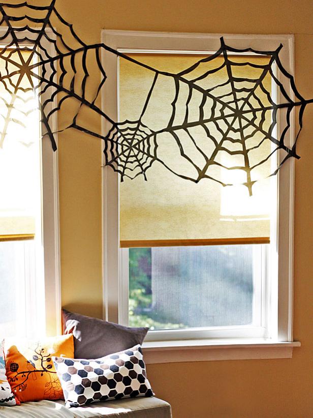 easy spooky Halloween decorations using black garbage bags to create spider webs