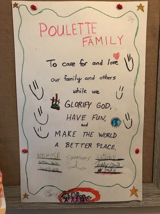 Poulette family mission statement example written on posterboard and hung on wall and signed by all the family members