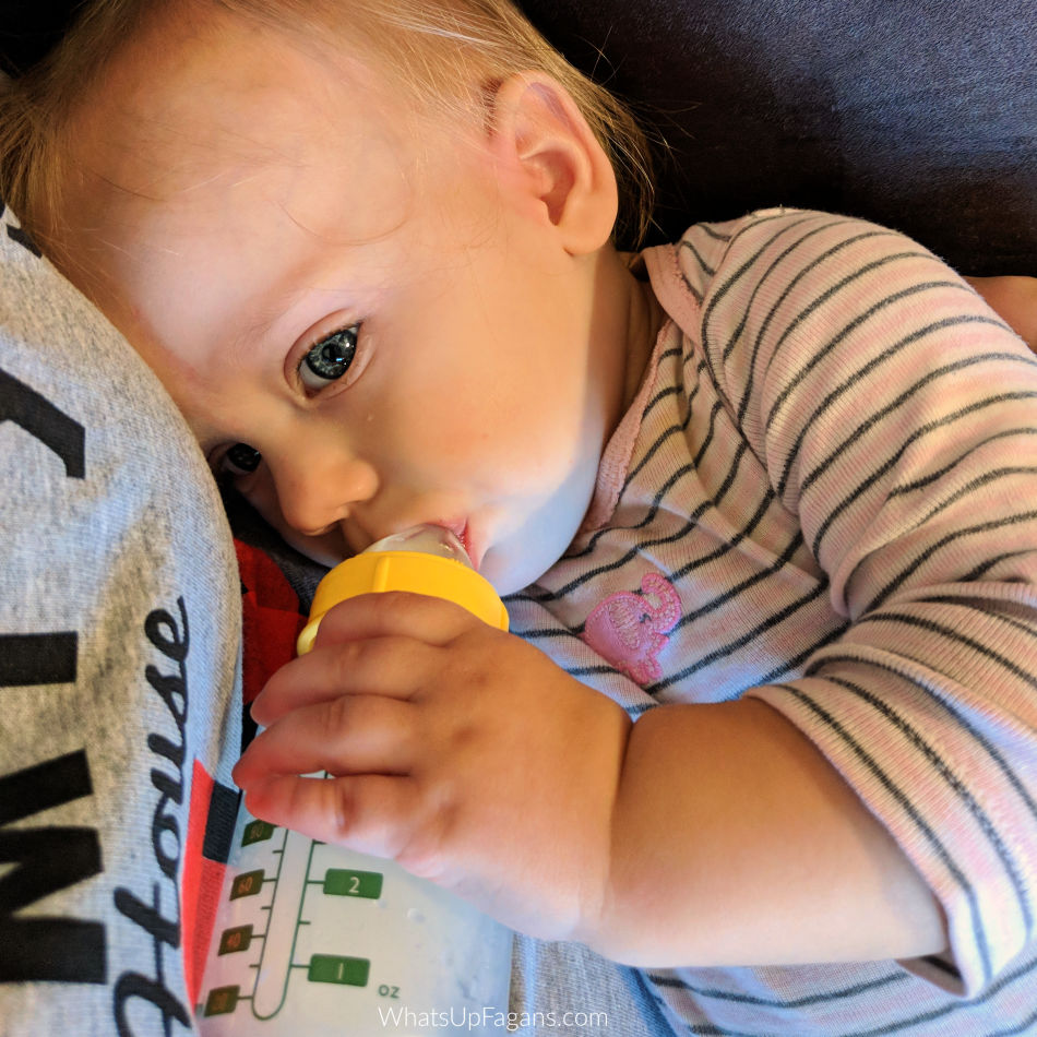 Baby drinking best breastfeeding supplement formula from her mother who is learning how to supplement with formula while breastfeeding